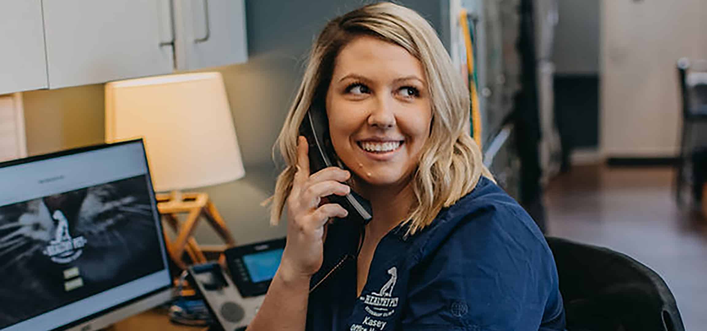 The Healthy Pet Veterinary Clinic office manager taking a call at their front desk