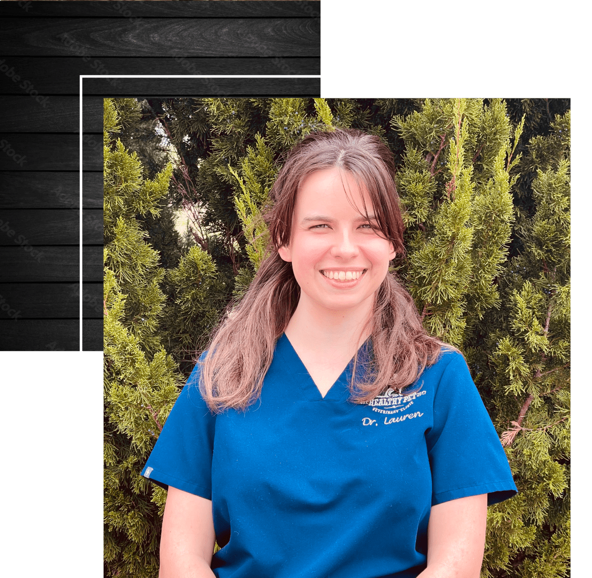 Kasey, the office manager, holding a small white dog while smiling at the camera